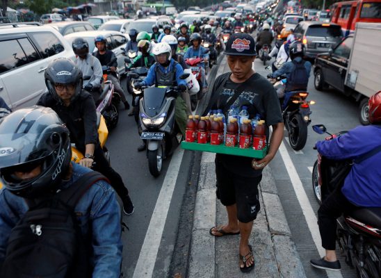 Un vendeur de rue au milieu des embouteillages à Jakarta. (Source : Nikkei Asian)