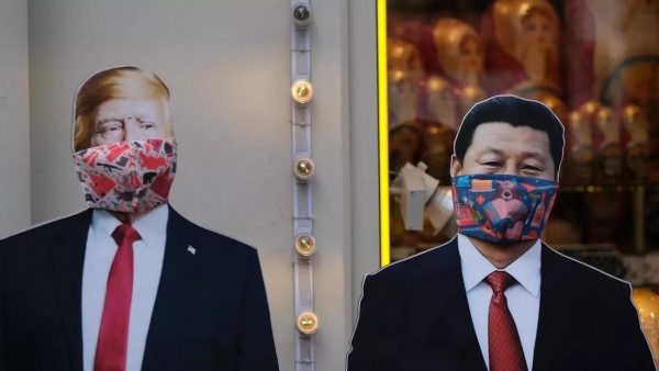 Deux effigies de Donald Trump et de Xi Jinping, masquées, dans une rue de Moscou en mars 2020. Crédit : REUTERS / Evgenia Novozhenina via RFI.