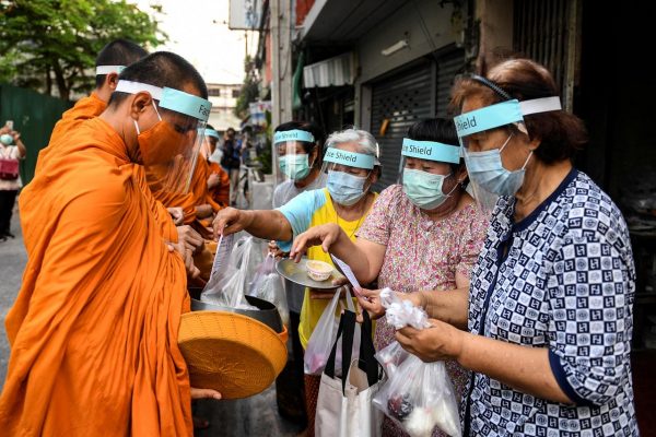 Des moines bouddhistes portant le masque pour se protéger du coronavirus récoltent l'aumône à Bangkok, le 31 mars 2020. (Source : Reuters)