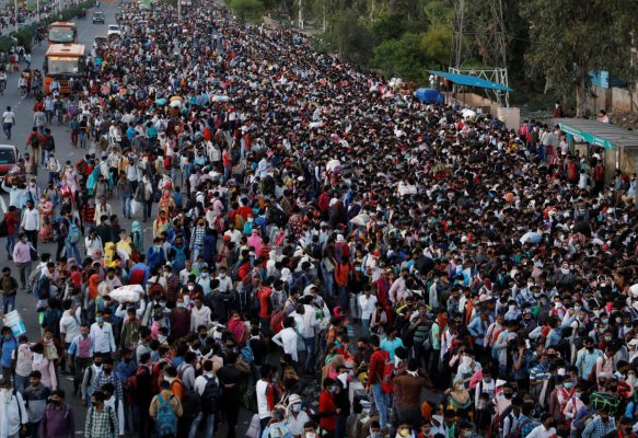 Une foule de travailleurs migrants tentent d'embraquer dans un bus pour rejoindre leur village, le 28 mars 2020, à Ghaziabad, dans la banlieue de Delhi, après la décision d'instaurer un confinement total de l'Inde pendant 21 jours. (Source : Asie Nikkei Review)