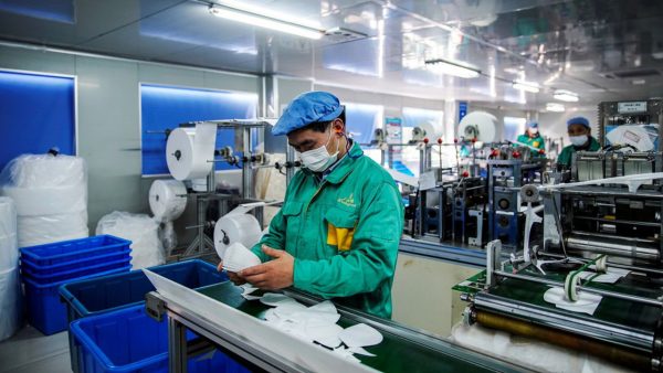 Des ouvriers chinois dans une usine de fabrication de masques à Shanghai, le 31 janvier 2020. (Source : Echos)