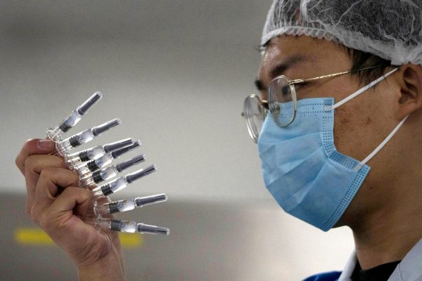 Un employé inspecte des seringues du vaccin contre le Covid-19 produit par Sinovac dans son usine de Pékin. (Source : LATIMES)