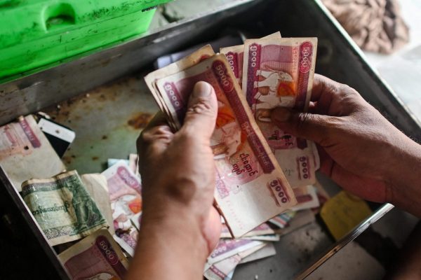 Un commerçant de Rangoun compte ses billets en khyats, la monnaie birmane, en mars 2020. (Source : Asia Times)
