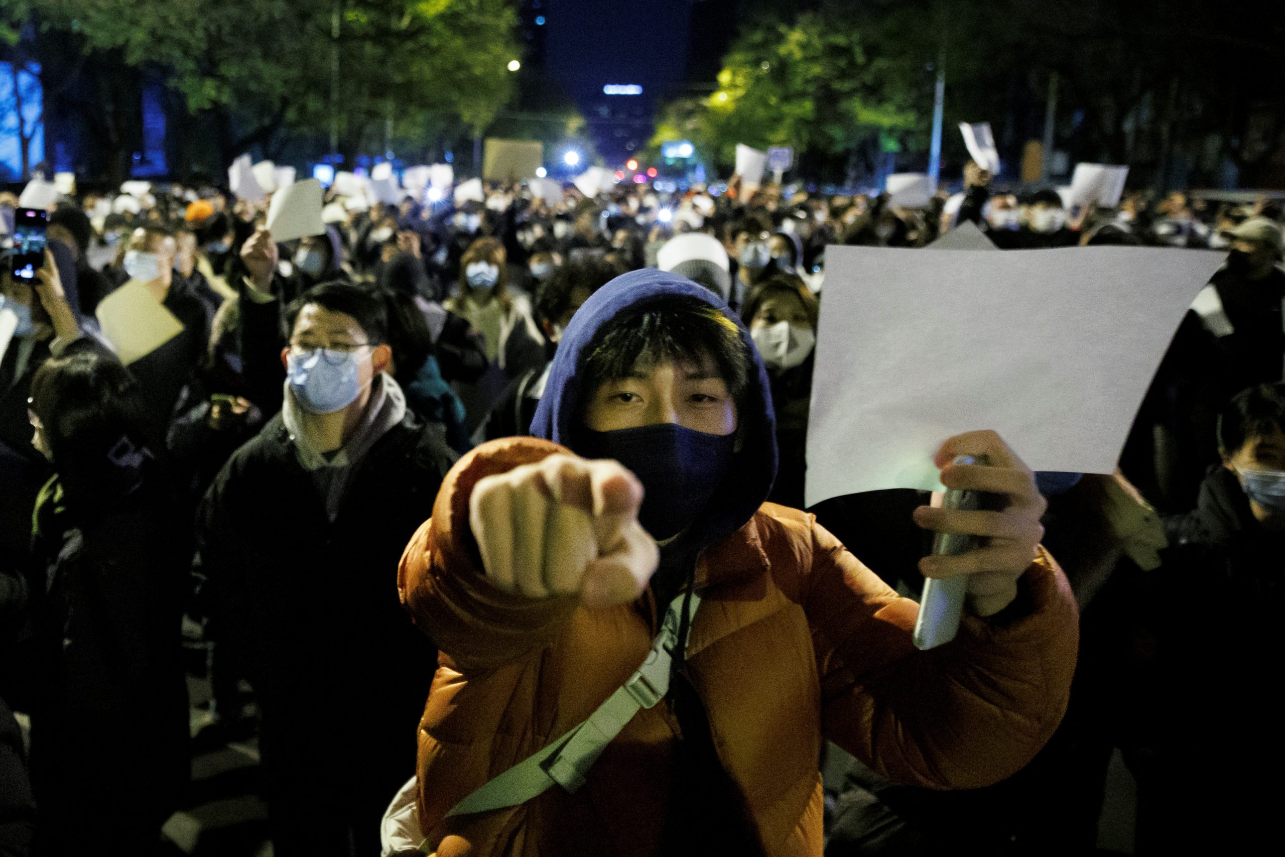 Des Pékinois brandissent des feuilles de papier blanc dans une manifestation contre la politique "zéro Covid", après un rassemblement en hommage aux victimes de l'incendie d'Urumqi, dans la capitale chinoise, le 27 novembre 2022. (Source : Reuters)