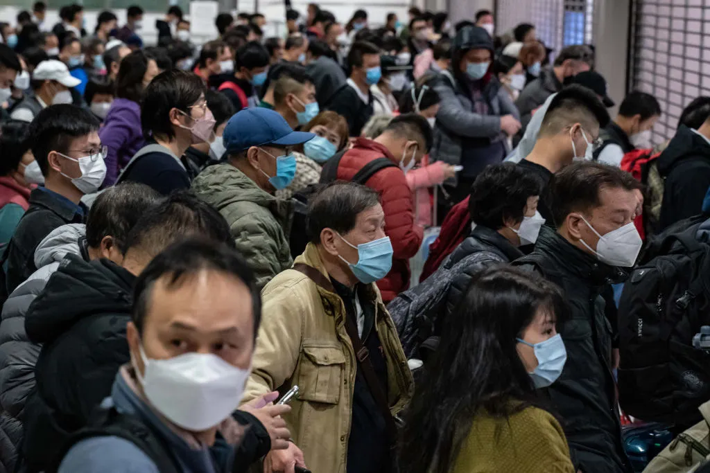 Des voyageurs attendent au poste frontière de Lok Ma Chau border à Hong Kong, le 8 janvier 2023. (Source : Time)