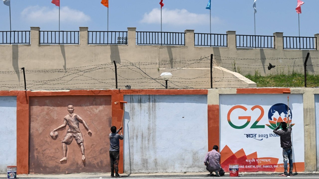Des ouvriers finalisent une publicité murale dans une rue pour la réunion du G20 à Srinagar, le 19 mai 2023. (Source : Deccan Herald)