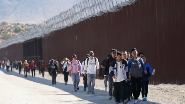 Migrants chinois le long du mur près de la ville californienne de Jacumba, après avoir traversé la frontière avec le Mexique pour demander l'asile aux États-Unis, le 24 octobre 2023. (Source : NBC)