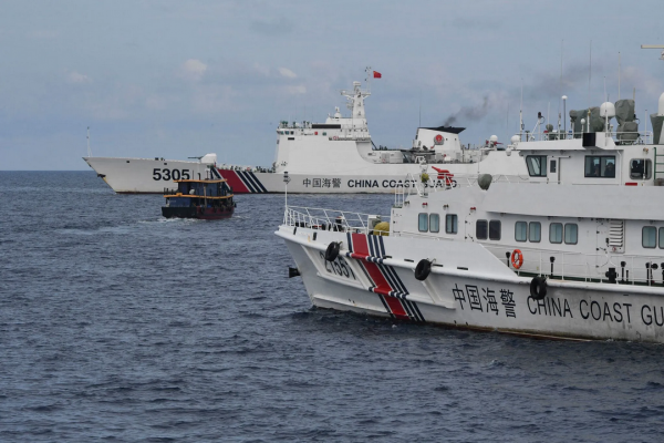 Des navires de garde-côtes chinois (à gauche et à droite) encadrent un bateau civil philippin affrété par la marine philippine dans la mer de Chine méridionale contestée, le 22 août 2023. (Source : La Croix)