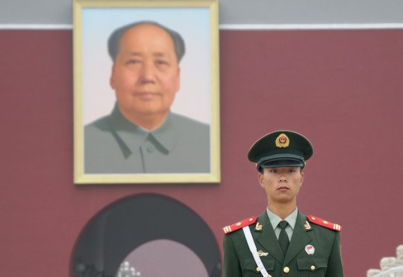 Un soldat chinois gardant l'entrée sud de la Cité Interdite à Pékin, dominée par un portrait immense de Mao Zedong.