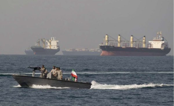Une vedette iranienne croise à proximité de navires commerciaux à l'embouchure du détroit d'Ormuz. DR.