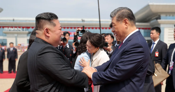 Xi Jinping et Kim Jong-un se serrent la main avec derrière eux les deux épouses qui se donnent l'accolade. DR.